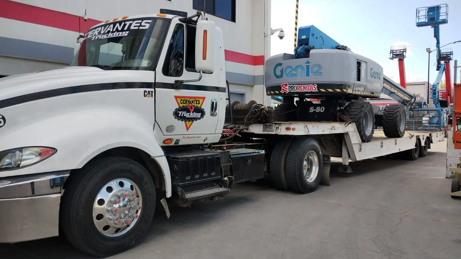 Camión de Grúas Cervantes Towing trasladando una plataforma de elevación Genie